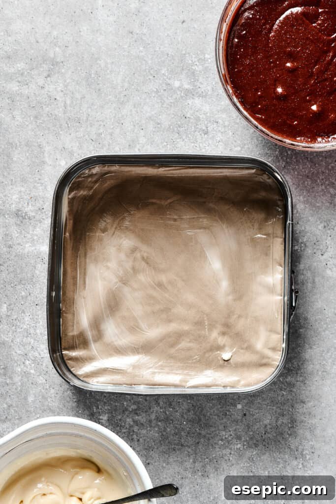 A 9x9 baking dish perfectly lined with parchment paper, ready for brownie batter.