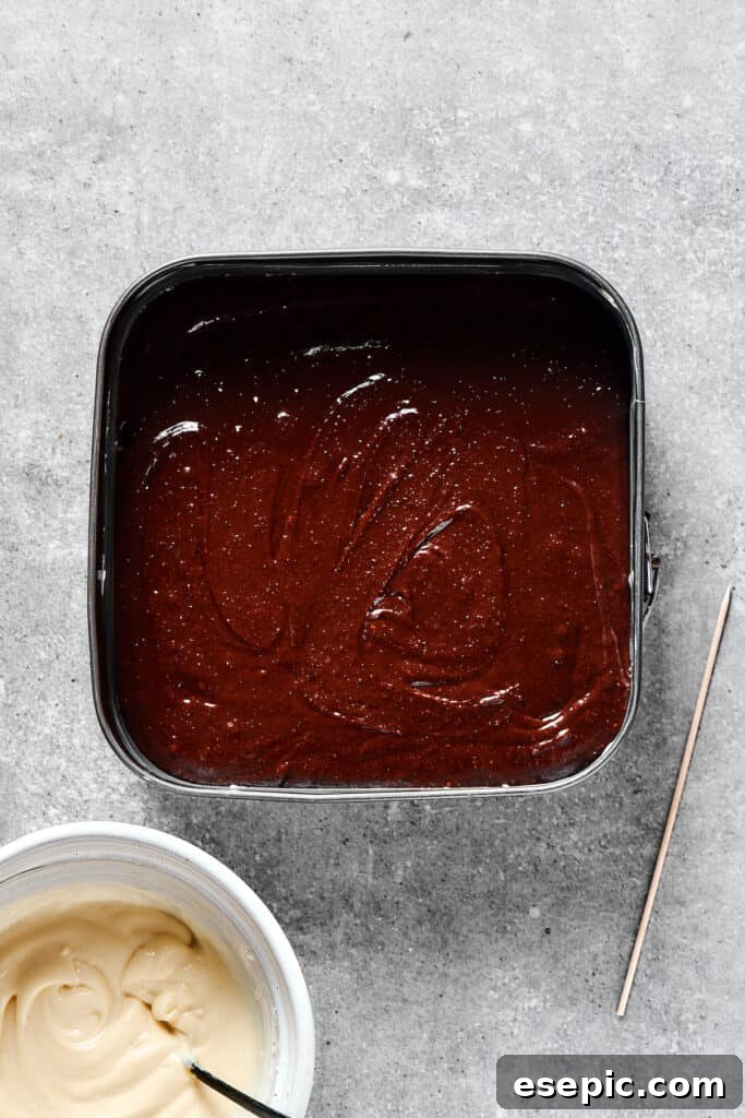 A pan filled with smooth, unbaked brownie batter, spread evenly.