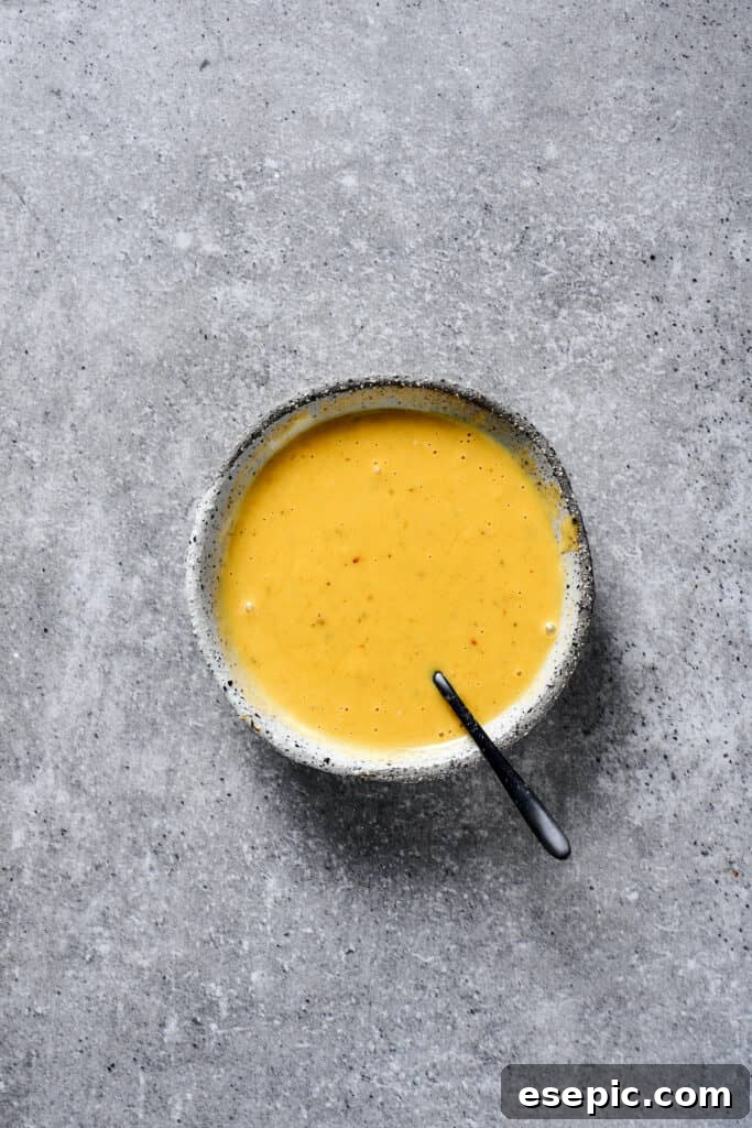 A small earthenware bowl of honey mustard sauce.