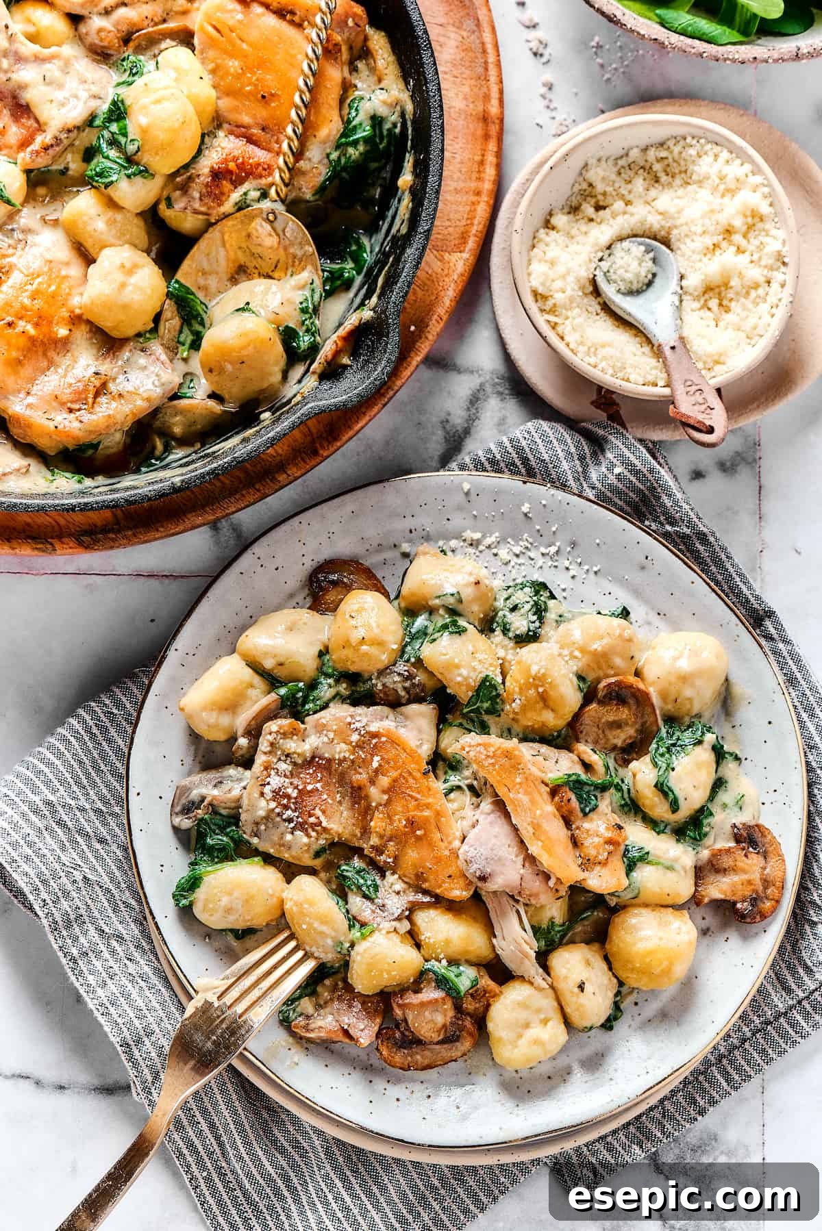 Creamy Chicken & Gnocchi Served on a Plate Overhead shot of a chicken skillet dish served onto a dinner plate, garnished with fresh herbs.