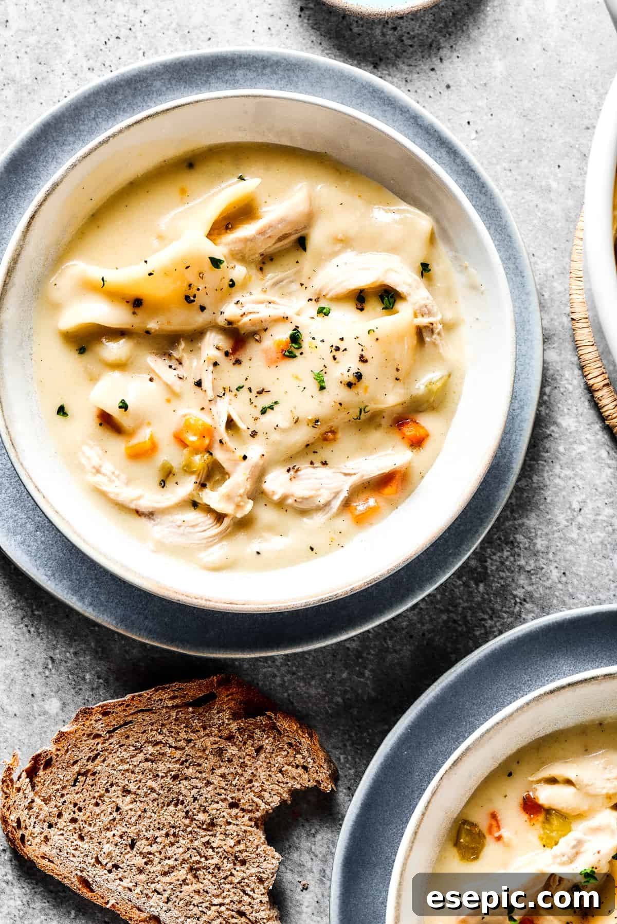 Southern-style Chicken and Dumplings are made with soft rolled dumplings, a rich, creamy broth, with tender pieces of white meat chicken. Creamy chicken and dumplings served into bowls.