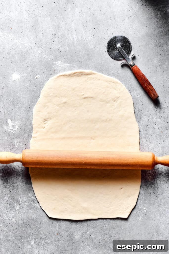 Simple Comfort Chicken and Dumplings 5 Rolling out dough on a work surface.