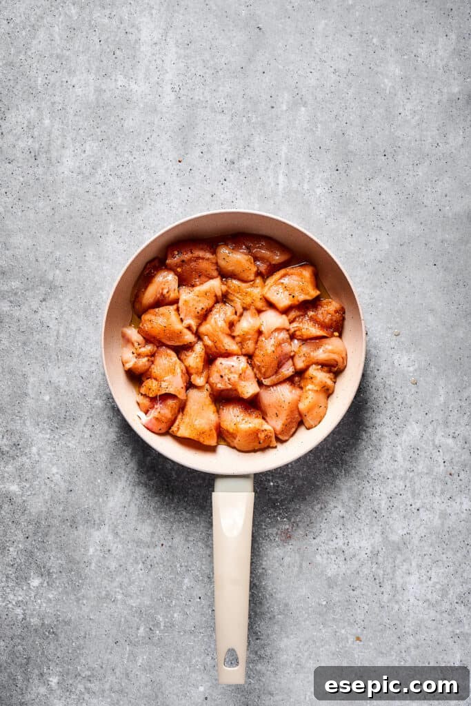 Raw chicken in a skillet.