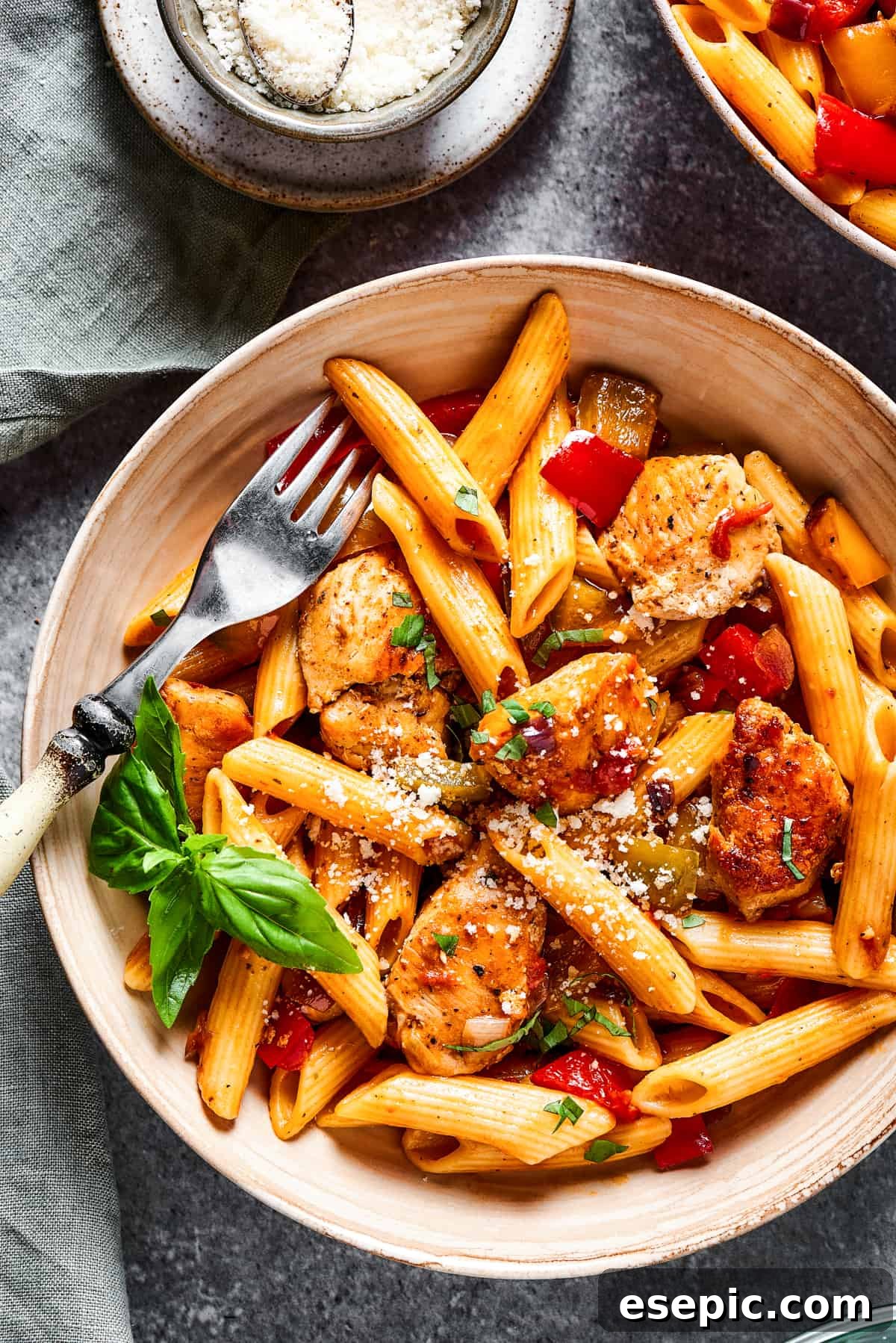 A bowl of chicken and pasta with a fork.