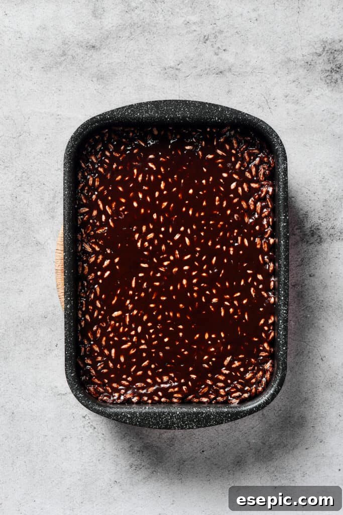 Irresistible Chocolate Crispy Bars 7 A baking pan filled with the dark chocolate rice cereal treats, pressed evenly and ready to cool.
