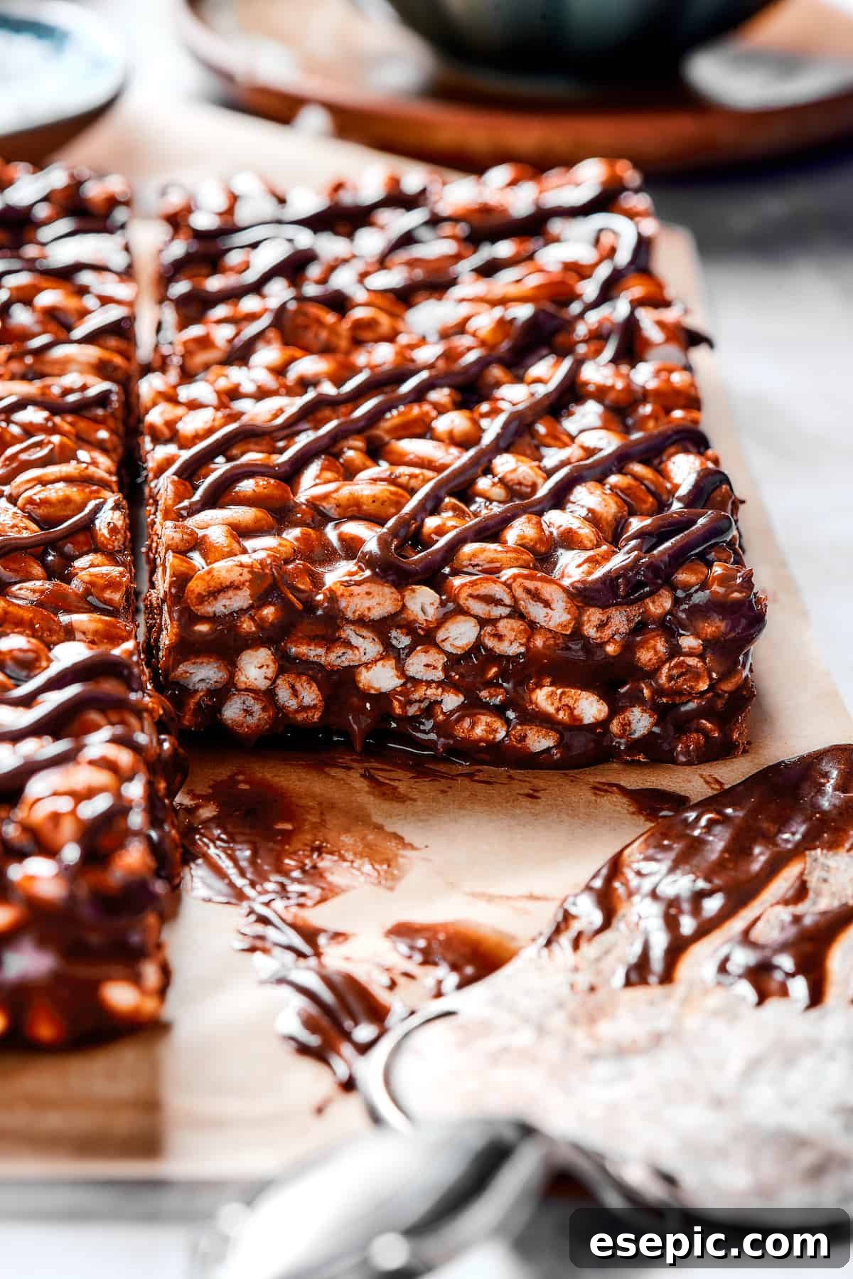 Homemade Chocolate Rice Krispie Treats topped with a smooth chocolate glaze. Close-up of a square chocolate cereal bar with a luscious chocolate and marshmallow topping, ready to be enjoyed.