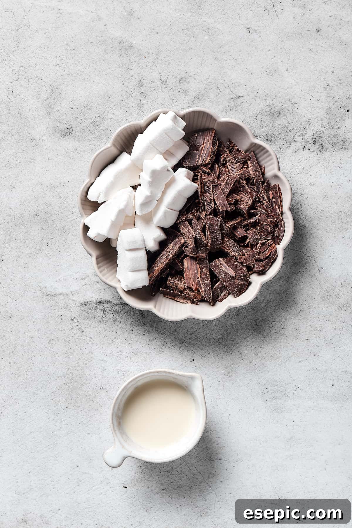 Fresh ingredients ready for preparing the chocolate topping. Ingredients for the chocolate topping: dark chocolate chips, marshmallows, and heavy cream in separate bowls.