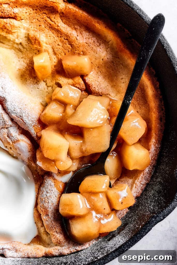 A skillet pancake with apples and creamy topping.