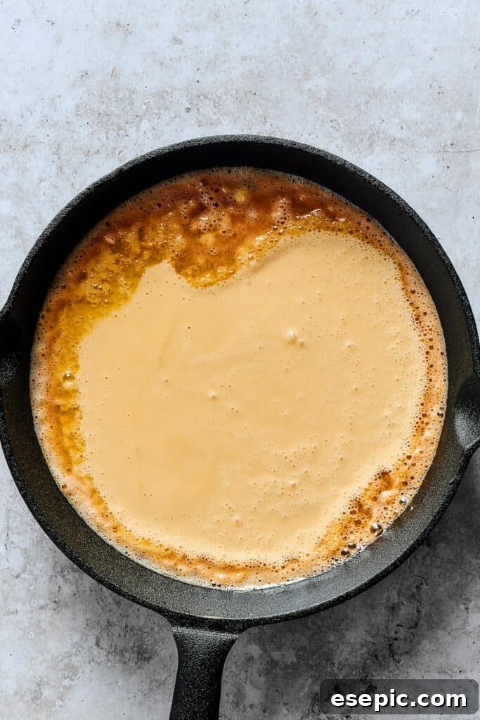 Batter poured into a buttery skillet.