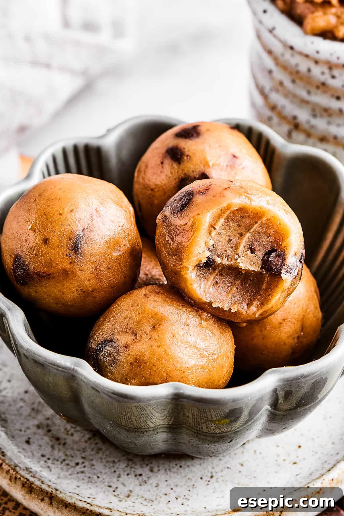 Edible cookie dough rolled into small, perfect balls and presented in a small fluted bowl.