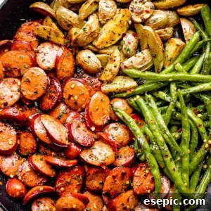 Close-up of the hearty one-pan meal, showcasing perfectly cooked smoked sausage, tender potatoes, and vibrant green beans, all beautifully combined in a black skillet.
