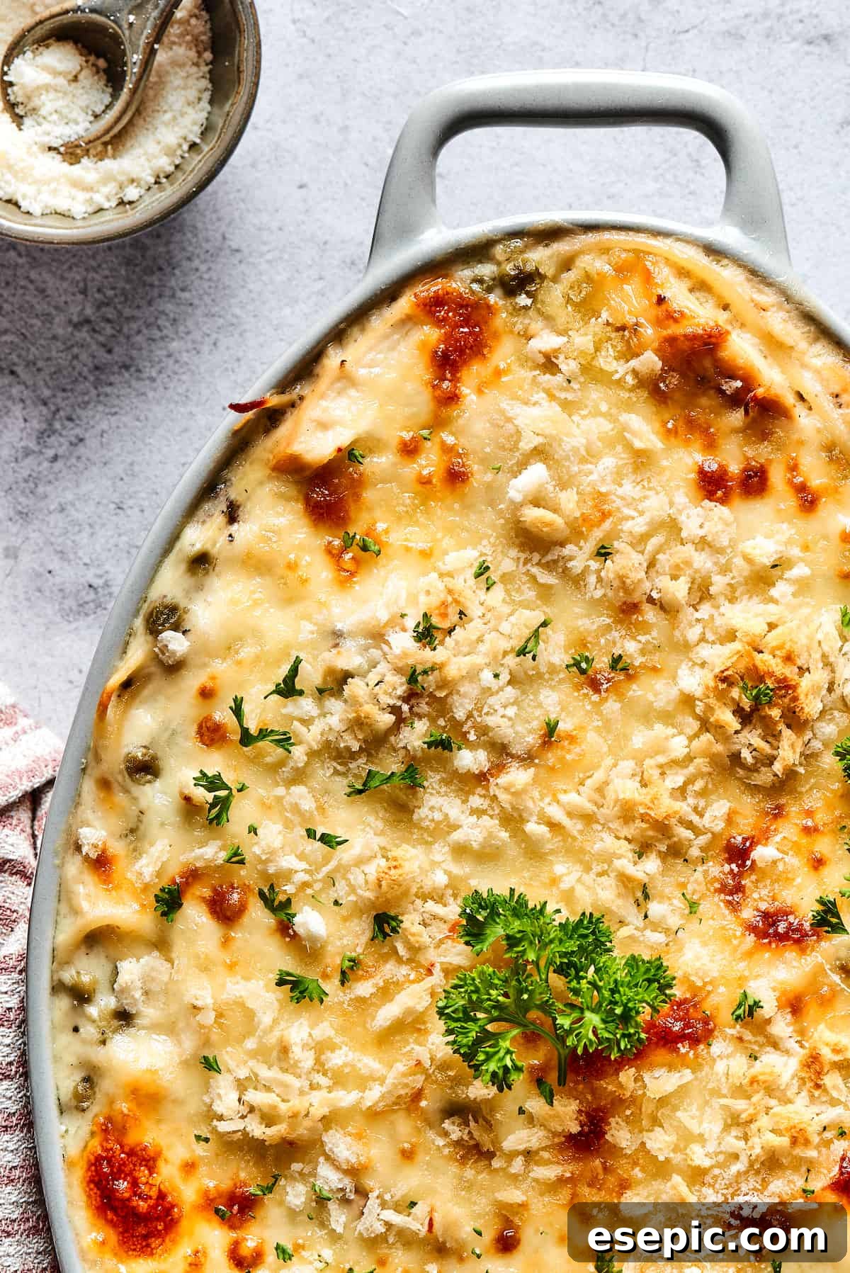 A baked chicken pasta casserole with a golden-brown and cheesy top, ready to be served from the dish.