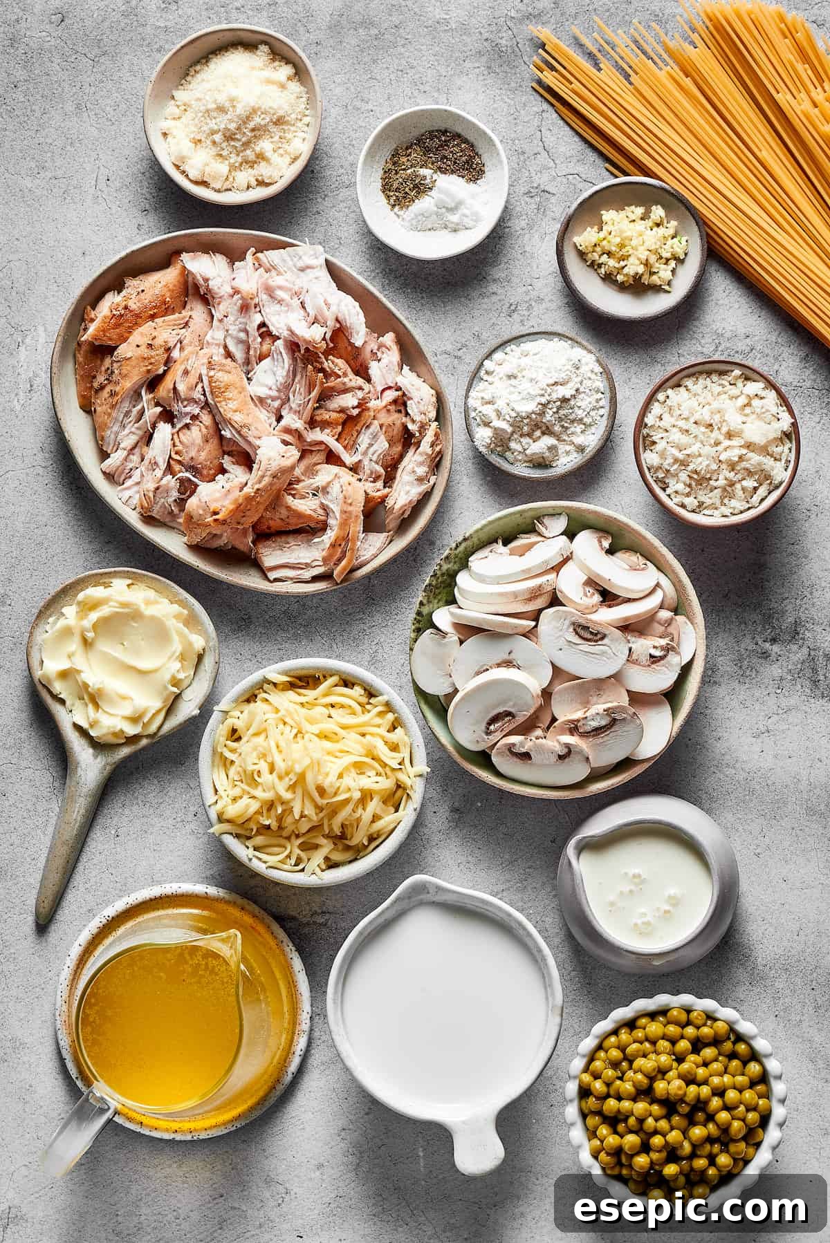Chicken tetrazzini ingredients, including chicken breasts, spaghetti, mushrooms, and dairy, are measured and arranged on a work surface, ready for preparation.