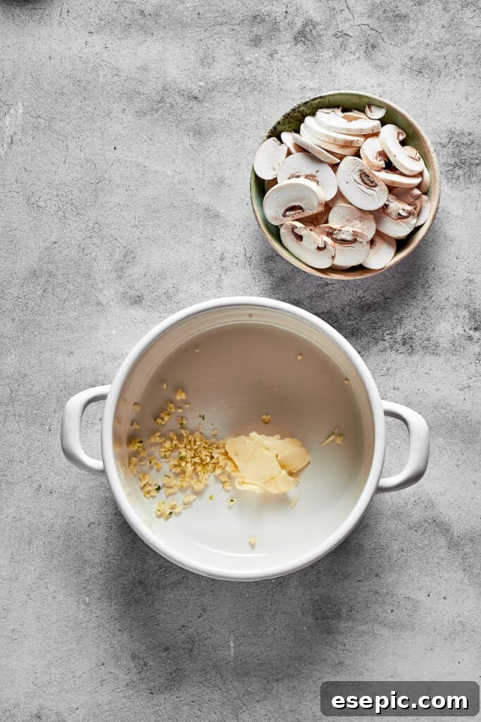Melted butter and minced garlic simmering in a soup pot, forming the aromatic base for the creamy sauce.