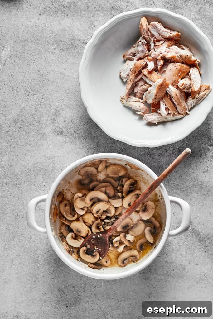 Sliced mushrooms being sautéed in a skillet, turning golden brown as they release their moisture and develop flavor.