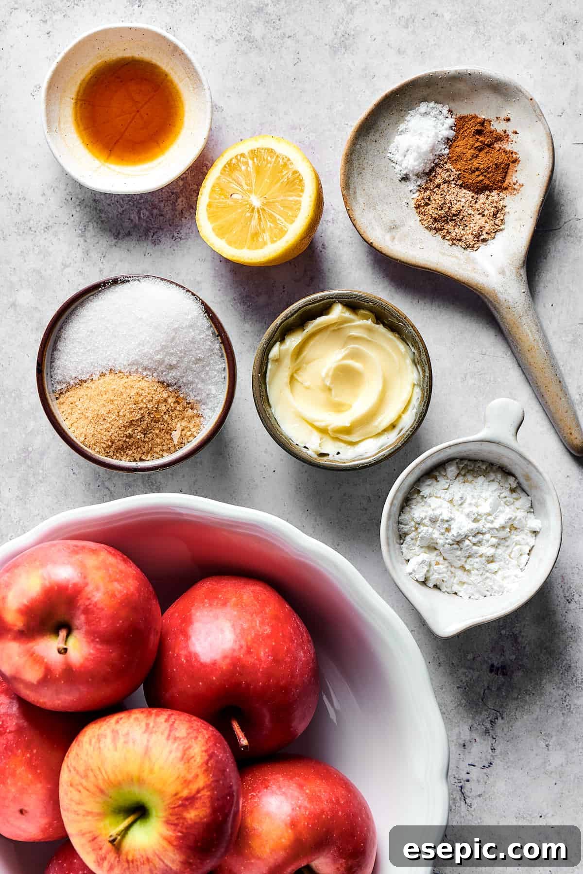 Measured apple filling ingredients, including apples, sugar, spices, and butter, neatly arranged on a work surface before cooking.