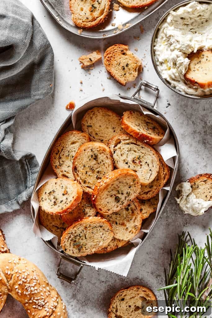Bagel chips arranged neatly in a small tin lined with parchment paper, ready for serving.