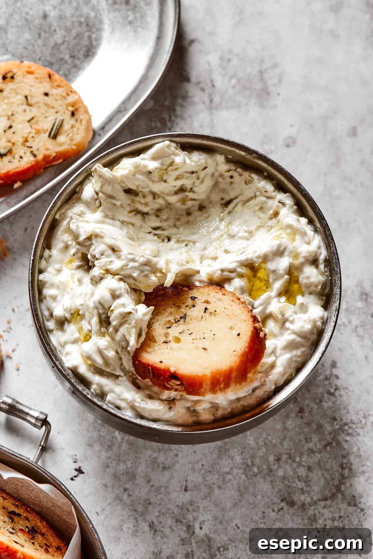 Dipping a bagel chip into a dish of creamy dip, highlighting the perfect snack experience.