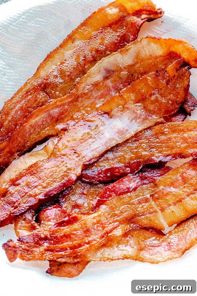 Close-up image of beautifully golden and crispy oven-baked bacon slices, ready to eat.