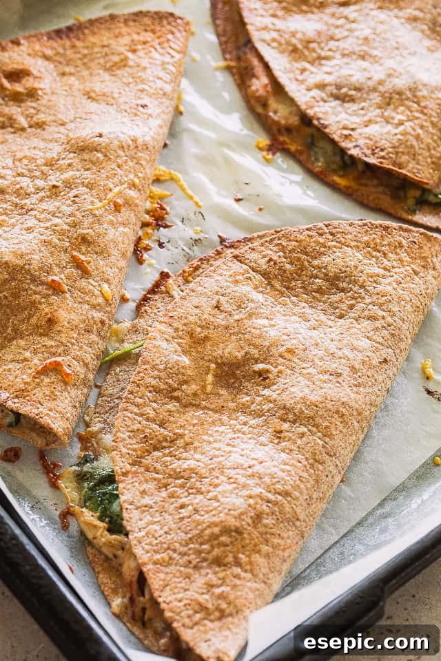These baked chicken quesadillas are stuffed with fresh spinach, melted cheese and shredded chicken. It's 100% kid approved and oh so good! Three golden brown, baked quesadillas fresh out of the oven.