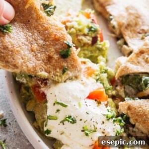 Oven-Crisped Chicken Quesadillas 2 A quesadilla being dipped in sour cream and guacamole, showing the delicious filling.
