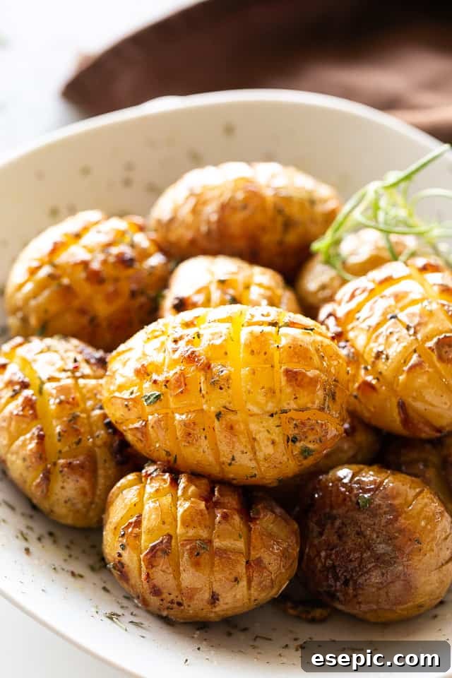 Golden Bristle Roast Potatoes 3 Serving of roasted hedgehog potatoes in a white bowl, garnished with fresh herbs, highlighting their golden crisp texture.