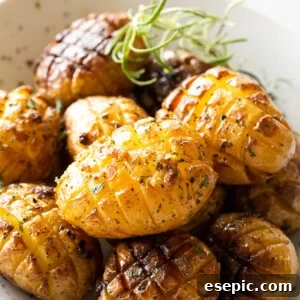 Roasted hedgehog potatoes served in a white bowl, garnished with fresh herbs, showcasing their golden crisp texture and delicious appeal.