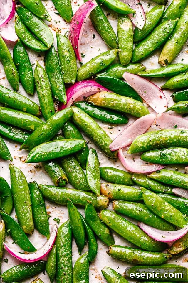 top view of roasted sugar snap peas and sliced red onions