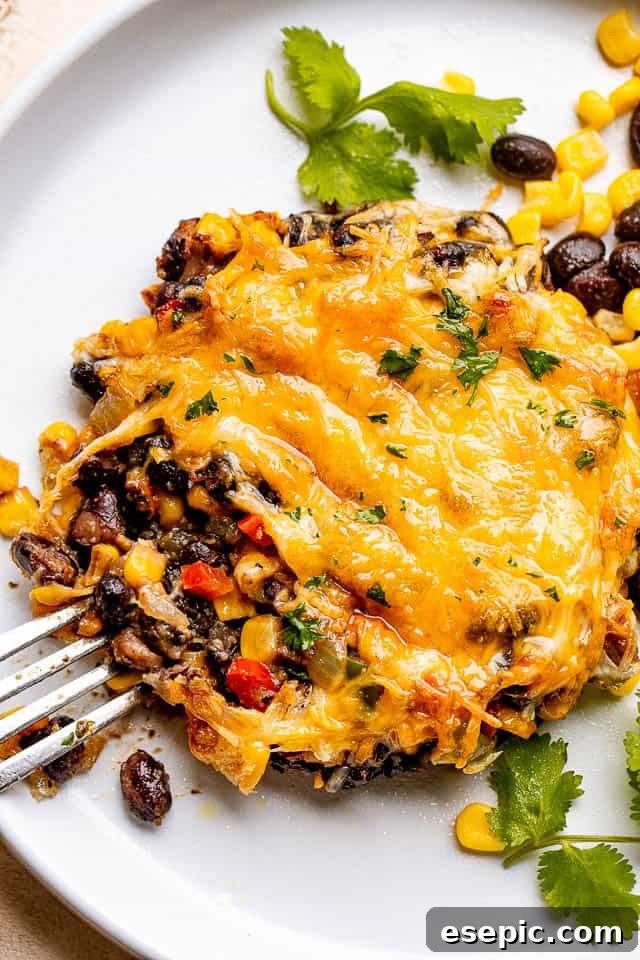 fork next to a mushroom stuffed with corn, black beans, and cheese