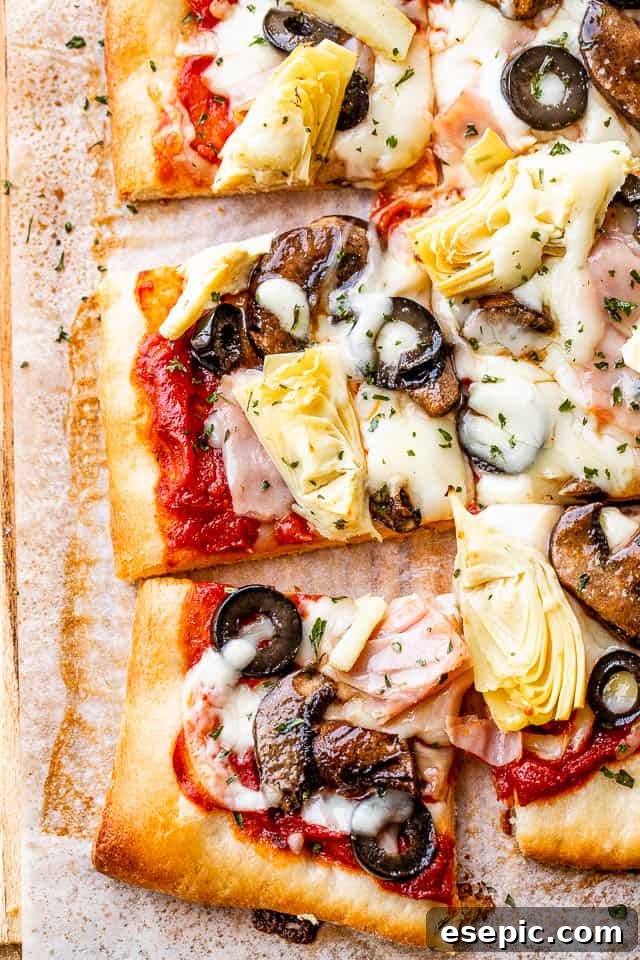 close up of capricciosa pizza topped with cheese, ham, mushrooms, and olives