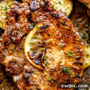 Close-up top view shot of baked pork chops topped with a slice of lemon