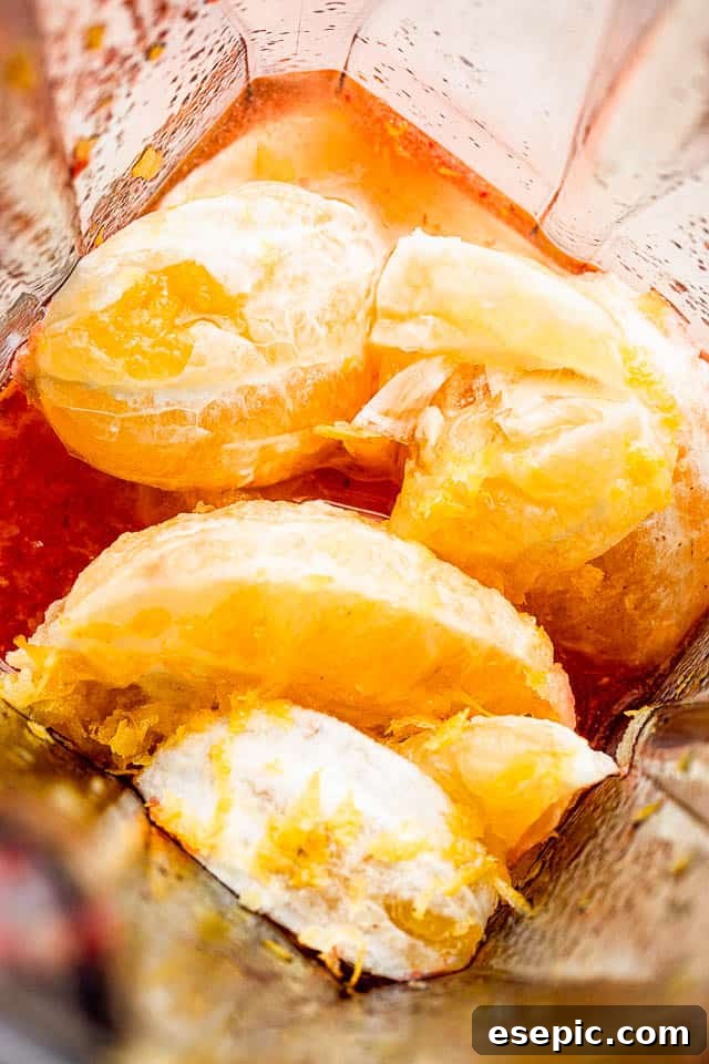 Peeled whole lemons in a blender, ready to be processed for fresh lemonade.