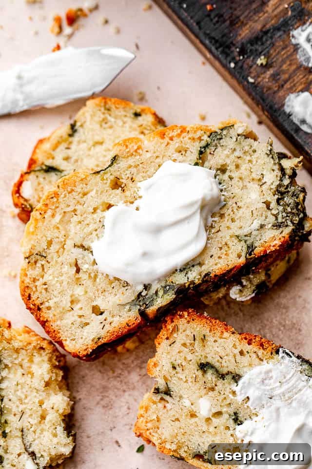close up shot of spinach and feta cheese no yeast bread slice topped with yogurt