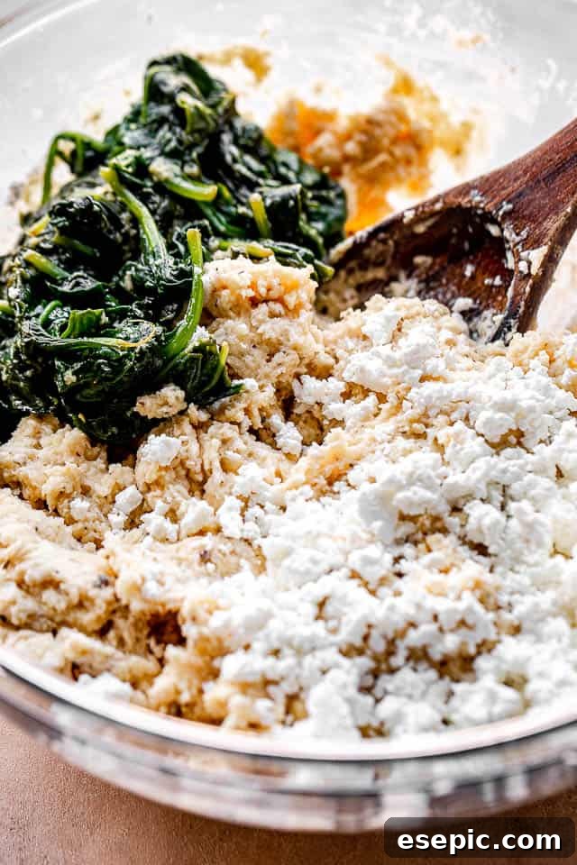 side view of a mixing bowl with spinach, cheese, and flour