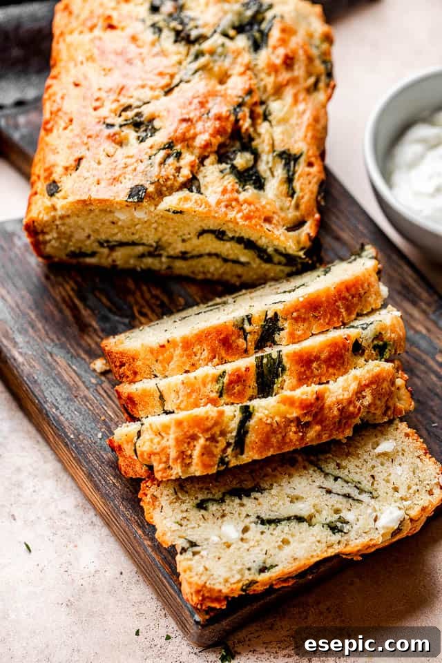 top shot of sliced spinach and feta bread set on top of a dark cutting board