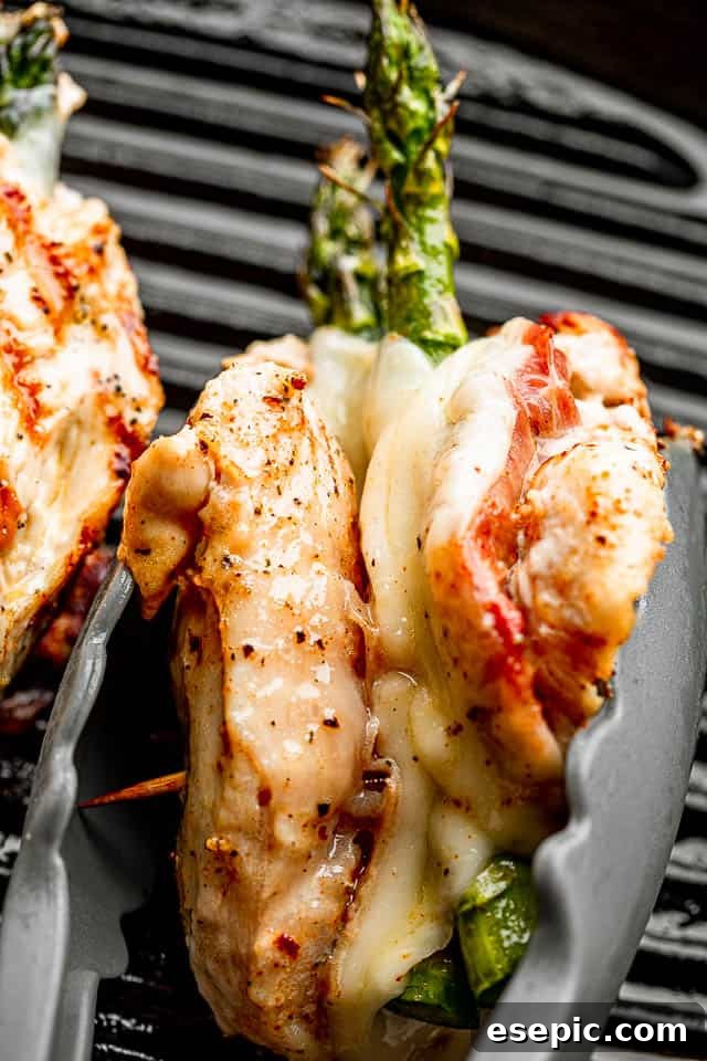 Chicken breast stuffed with prosciutto, cheese, and asparagus, held with tongs
