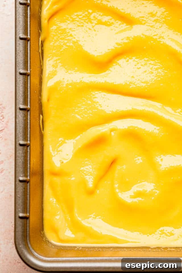 Blended mango yogurt mixture in a white loaf pan, ready for the strawberry swirl