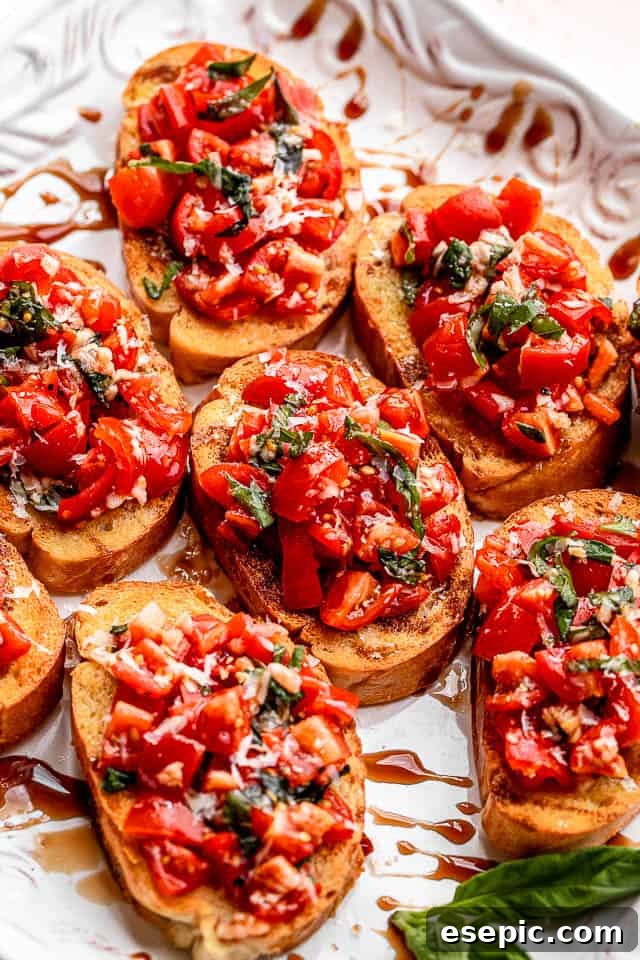 Garlic bread bruschetta with balsamic glaze. A stunning white platter adorned with perfectly assembled garlic bread bruschetta, topped with a balsamic tomato salad and a delicate drizzle of balsamic glaze, ready to be enjoyed.