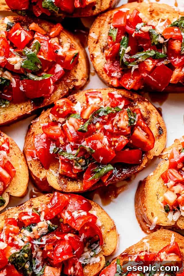 Close-up of vibrant garlic bread bruschetta. A close-up view of freshly made garlic bread bruschetta, highlighting the vibrant colors and appealing textures of the tomato and basil topping with a glossy balsamic glaze.