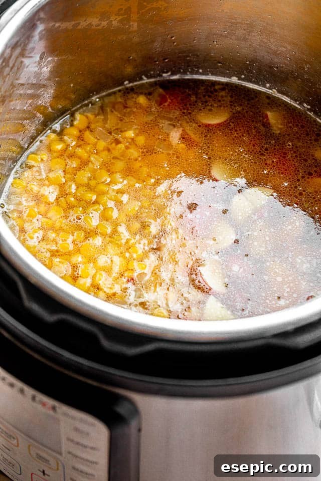 Close-up shot of corn chowder being cooked in an Instant Pot, showing the ingredients simmering inside.