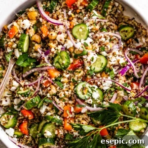 Overhead shot of Jennifer Aniston's bulgur salad in a bowl, showcasing tri-color quinoa, roasted chickpeas, feta, and fresh vegetables.