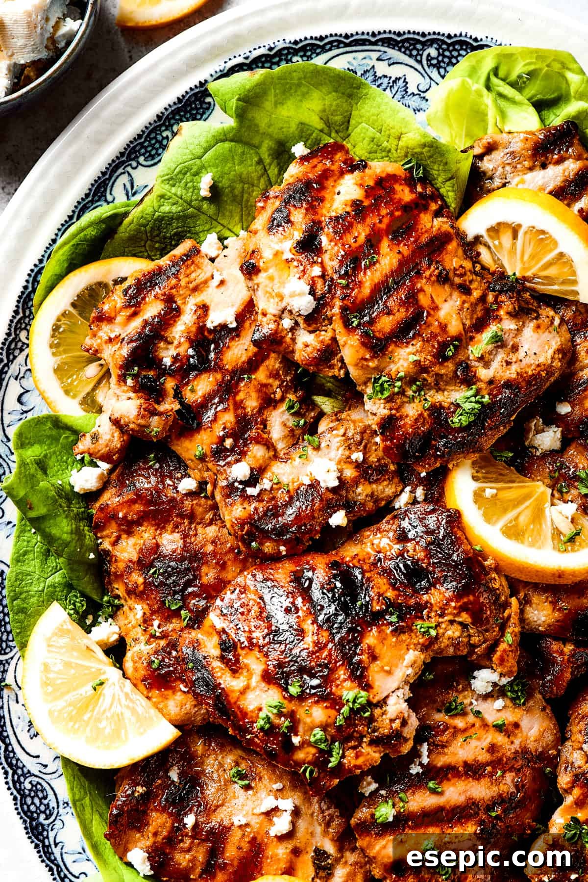 Yogurt Marinated Chicken is an easy grilled chicken recipe that’s versatile, zesty, and easy to make. Everyone will rave over this easy dish! A platter of yogurt-marinated chicken with grill marks.