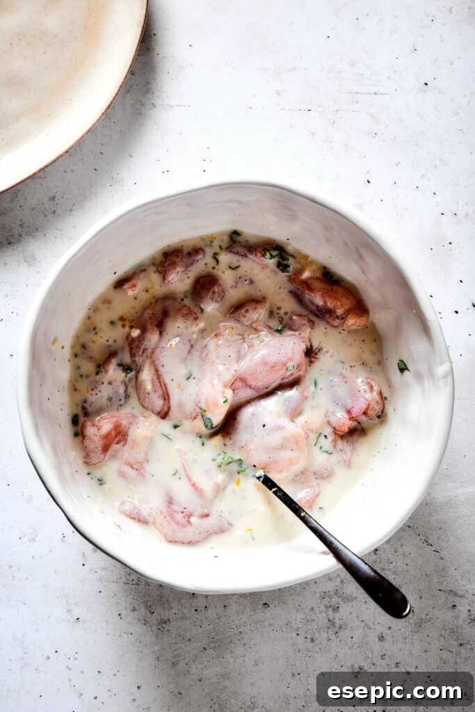 Yogurt Marinated Chicken is an easy grilled chicken recipe that’s versatile, zesty, and easy to make. Everyone will rave over this easy dish! Adding chicken to yogurt marinade.