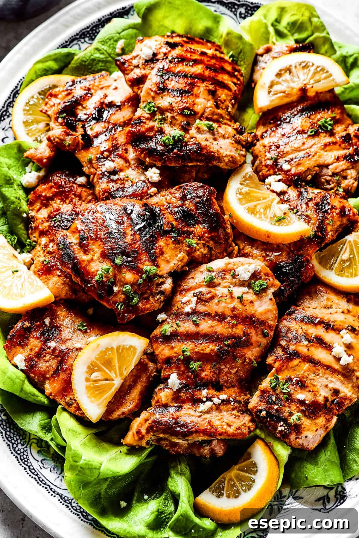 Yogurt Marinated Chicken is an easy grilled chicken recipe that’s versatile, zesty, and easy to make. Everyone will rave over this easy dish! Yogurt-marinated chicken grilled set atop a bed of lettuce leaves and topped with feta cheese.