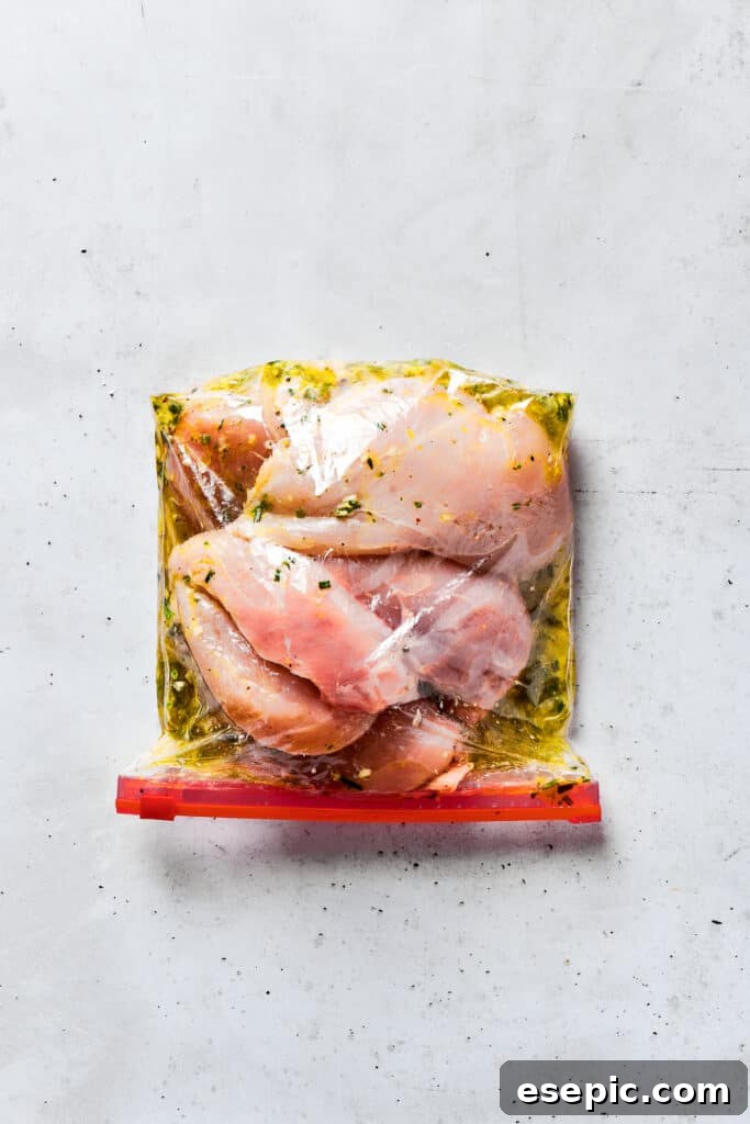Chicken breasts in a zip-top bag coated with marinade.