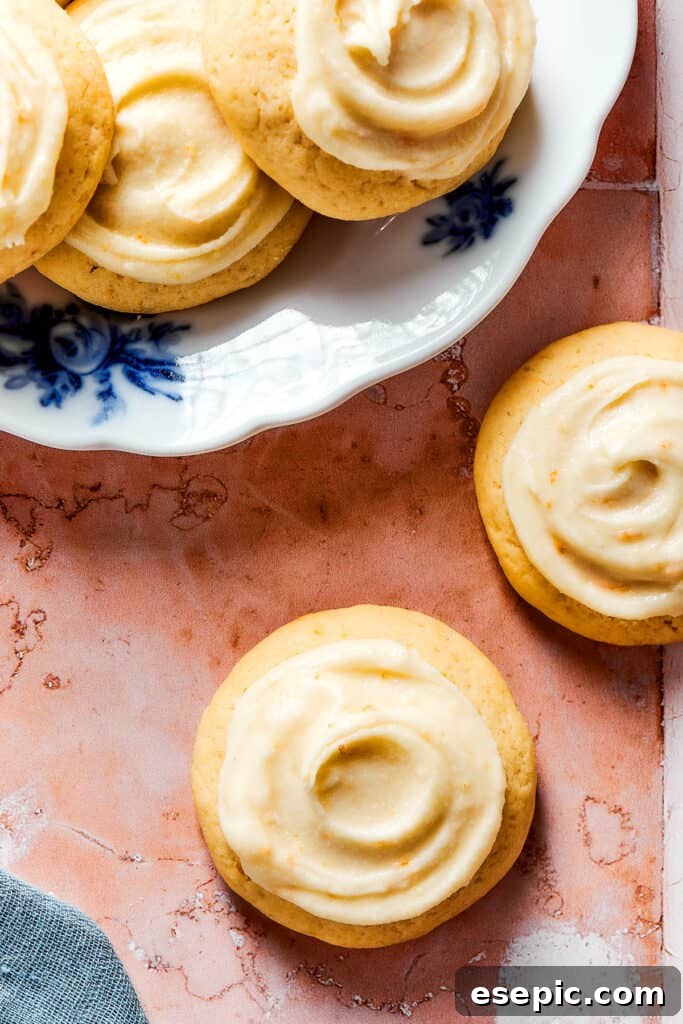 Sweet, buttery Orange Cookies have a light citrus taste and pretty pastel color - perfect for parties, cookie swaps, baby showers, and more! Orange cookies with homemade icing swirled on top.