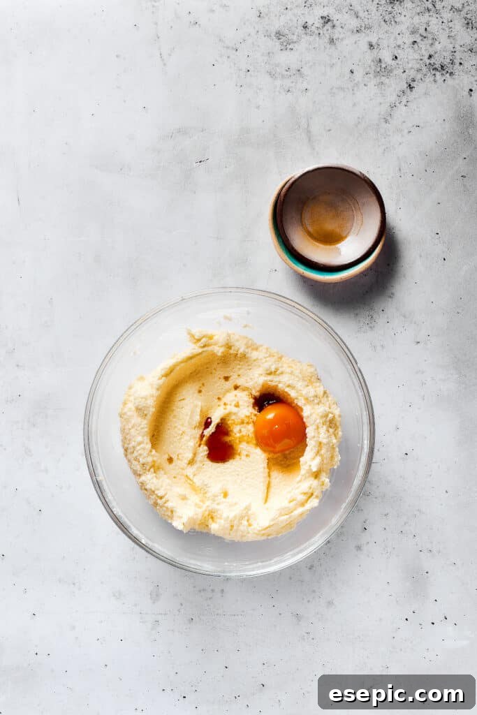 Sweet, buttery Orange Cookies have a light citrus taste and pretty pastel color - perfect for parties, cookie swaps, baby showers, and more! Adding egg yolks, vanilla, and other ingredients to creamed butter and sugar.