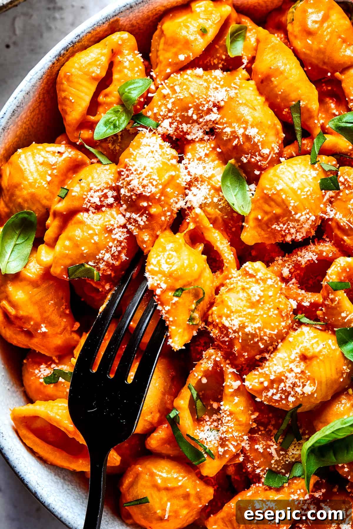 Gigi Hadid Pasta is an easy recipe that every busy cook should know! With tender pasta, red pepper flakes, and cream, it's total comfort food. A fork in a bowl of Gigi Hadid pasta, garnished with fresh basil.