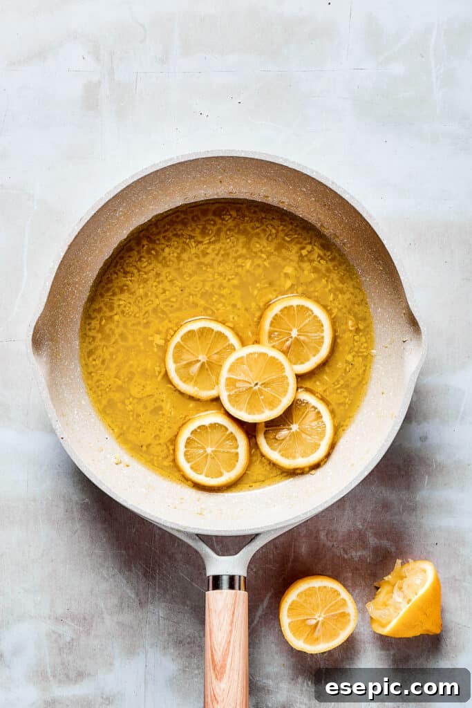 Lemon slices added to a skillet of sauce.