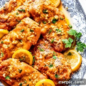 Homemade lemon chicken recipe arranged on a platter with parsley and lemon slices.